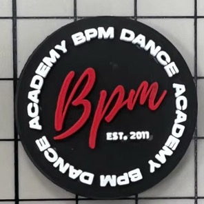 The round black BPM croc charm: the red BPM script logo inside BPM Dance Academy lettering